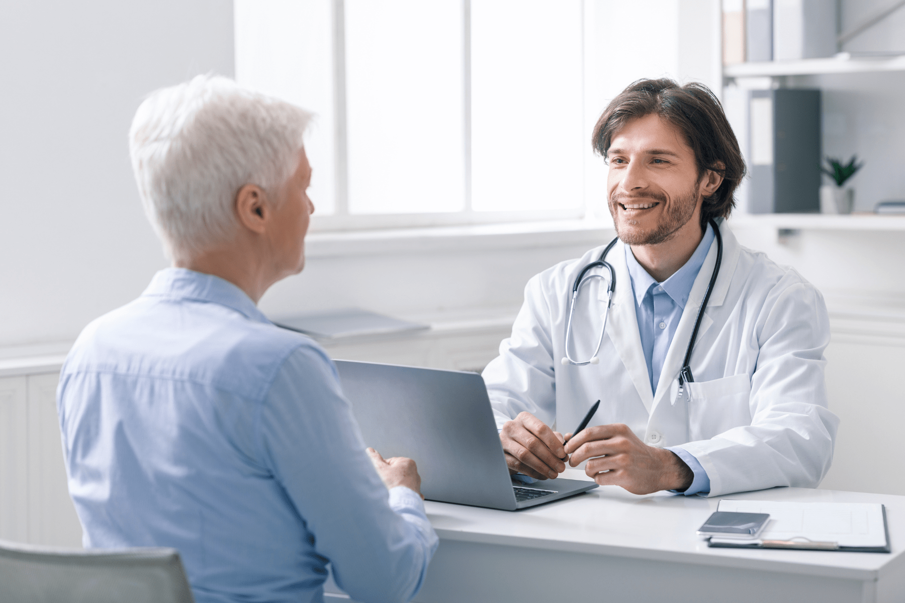 A doctor smiling while talking with an older patient